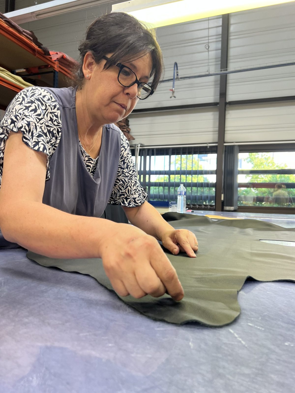 A stitcher at work. She analyzes the leather for perfection.