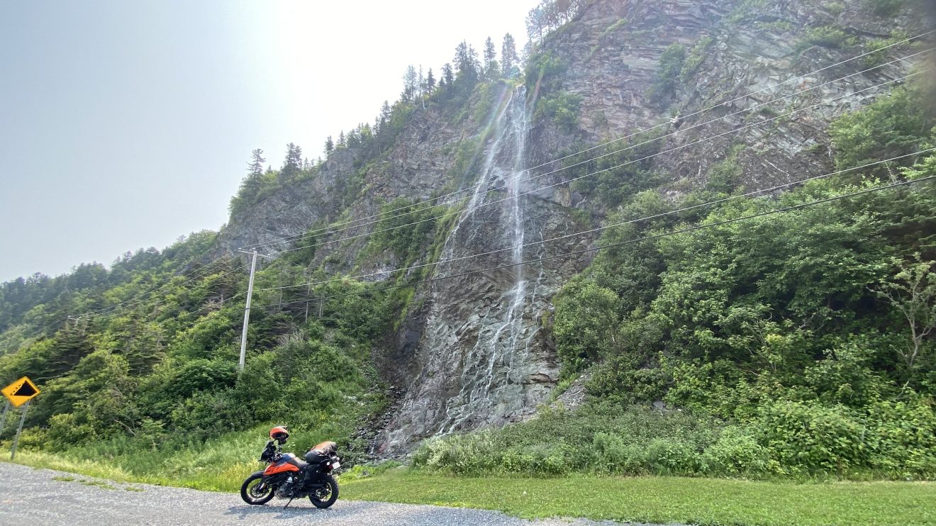 moto devant une chute d'eau en gaspésie