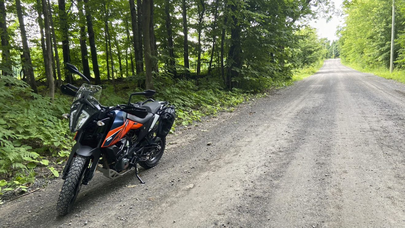 une moto KTM 390 Adventure sur le bord d'une route de gravier